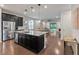 Modern kitchen with stainless steel appliances, granite counters, dark cabinets, and an island with pendant lights at 11434 Spring Gate Trl, Bradenton, FL 34211