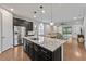 Modern kitchen with stainless steel appliances, granite counters, dark cabinets, and an island with pendant lights at 11434 Spring Gate Trl, Bradenton, FL 34211