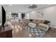 Spacious living room with open concept view to the kitchen, large sectional sofa, and stylish rug on hardwood floors at 11434 Spring Gate Trl, Bradenton, FL 34211
