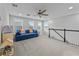 Bright loft with a large blue couch, neutral carpet, and bright natural light at 11434 Spring Gate Trl, Bradenton, FL 34211