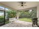 Screened patio featuring tile flooring, ceiling fan, a white bench, and outdoor views at 11434 Spring Gate Trl, Bradenton, FL 34211
