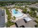 Aerial view of the community pool area with seating, palm trees, and nearby landscaping at 11434 Spring Gate Trl, Bradenton, FL 34211