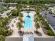 Aerial view of the community pool, surrounded by palm trees, lounge seating, and a covered patio at 11434 Spring Gate Trl, Bradenton, FL 34211