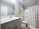 Bright bathroom featuring a white vanity with gray cabinets and a shower with multicolored polka dot curtain at 12832 Oak Hill Way, Parrish, FL 34219