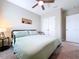Cozy bedroom with a queen-sized bed, soft carpet, and a ceiling fan for added comfort at 12832 Oak Hill Way, Parrish, FL 34219