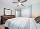 Comfortable bedroom with a wooden dresser, closet doors, ceiling fan and a king bed at 12832 Oak Hill Way, Parrish, FL 34219