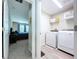 Convenient laundry room with modern appliances, shelving, and access to the bedroom at 12832 Oak Hill Way, Parrish, FL 34219