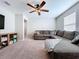 Spacious living room featuring a large grey sofa, ceiling fan, and open layout, perfect for relaxation at 12832 Oak Hill Way, Parrish, FL 34219
