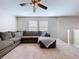 Comfortable living room area with plush grey sofa, ceiling fan, and bright natural light at 12832 Oak Hill Way, Parrish, FL 34219