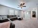 Living room showcases a plush grey sofa, ceiling fan, and natural light streaming in through the blinds at 12832 Oak Hill Way, Parrish, FL 34219