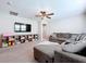 Bright living room with a big grey couch, ceiling fan, and built in shelving at 12832 Oak Hill Way, Parrish, FL 34219