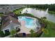 Community pool features resort-style lounge seating, pergola, and lake views at 12832 Oak Hill Way, Parrish, FL 34219