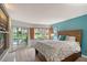 Bright bedroom featuring a large window with shutter, access to a patio, and a wooden bedframe at 1300 N Portofino Dr # 103, Sarasota, FL 34242