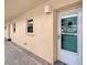 Exterior shot of a condo entrance featuring a clean door and a small window to the side at 1300 N Portofino Dr # 103, Sarasota, FL 34242