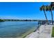 Scenic waterfront view with a private dock, benches, and lush greenery enhancing the serene setting at 1300 N Portofino Dr # 103, Sarasota, FL 34242