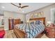 Comfortable bedroom featuring a ceiling fan, wood-look floors, and a decorative no wake zone pillow at 1461 Marlin St, Nokomis, FL 34275