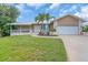 Charming single-story home features a lush lawn, two-car garage, and covered front porch with stone accents at 1461 Marlin St, Nokomis, FL 34275
