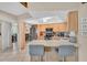 Open kitchen with light wood cabinets, stainless steel appliances, and a breakfast bar with seating for two at 1461 Marlin St, Nokomis, FL 34275