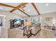 Inviting living room featuring vaulted ceilings, wood beams, stylish decor, and an entertainment center at 1461 Marlin St, Nokomis, FL 34275