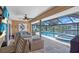 Relaxing covered patio with outdoor seating, ceiling fan, and a view of the pool and waterfront at 1461 Marlin St, Nokomis, FL 34275