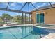 Sparkling screened-in pool and spa overlooking the waterfront with tile surround and boat dock at 1461 Marlin St, Nokomis, FL 34275