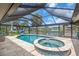 Screened in pool and spa overlooking the waterfront with tile surround and metal framework at 1461 Marlin St, Nokomis, FL 34275