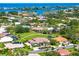 Aerial view of a home in a Sarasota neighborhood near waterfront, lush green lawns, and mature trees at 1484 Seafarer Dr, Osprey, FL 34229