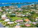 Aerial view of a home in a neighborhood close to the water with large lawns and mature trees at 1484 Seafarer Dr, Osprey, FL 34229