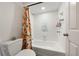 Bathroom features a white tiled shower over tub with a colorful curtain and a white toilet at 1484 Seafarer Dr, Osprey, FL 34229