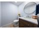 Half bath with designer wallpaper, vanity, and round mirror at 1484 Seafarer Dr, Osprey, FL 34229