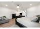 A well-lit bedroom featuring a dark bed frame, hard wood floors, and a sitting area at 1484 Seafarer Dr, Osprey, FL 34229