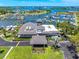 Aerial of the clubhouse with beautifully manicured landscaping, a circular driveway, and a scenic waterfront backdrop at 1484 Seafarer Dr, Osprey, FL 34229