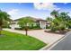 Charming property with a lush lawn, tropical palm trees, and a brick-paved driveway leading to a modern home at 1484 Seafarer Dr, Osprey, FL 34229