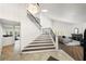 Grand foyer with staircase featuring wood treads, leading to a living area with a fireplace and abundant natural light at 1484 Seafarer Dr, Osprey, FL 34229