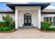 Stunning front entrance with black double doors, decorated with wreaths, framed by a red brick-paved driveway at 1484 Seafarer Dr, Osprey, FL 34229