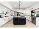 Spacious white kitchen with dark island, stainless steel appliances and granite counters at 1484 Seafarer Dr, Osprey, FL 34229