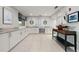 Modern kitchenette with sleek white cabinetry, marble countertops, stainless steel appliances, and stylish nautical decor at 1484 Seafarer Dr, Osprey, FL 34229