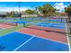 Community pickleball courts with blue and red surface colors, lights and net at 1484 Seafarer Dr, Osprey, FL 34229