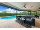Relaxing covered pool area with a comfortable lounge seating area perfect for enjoying the outdoors at 1484 Seafarer Dr, Osprey, FL 34229