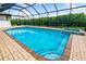 A refreshing pool and spa are surrounded by brick pavers within a screened enclosure at 1484 Seafarer Dr, Osprey, FL 34229