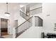 Bright foyer featuring a modern staircase with wood railing, complemented by a contemporary chandelier, and white walls at 1484 Seafarer Dr, Osprey, FL 34229