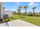 Lush backyard with green lawn, privacy fence, and young palm trees at 16652 Bergamo Pl, Bradenton, FL 34211