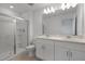 A bright, white bathroom with double vanity, large mirror, and glass shower enclosure at 16652 Bergamo Pl, Bradenton, FL 34211
