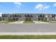 Street view of newly built townhomes with manicured lawns and sidewalks on a sunny day at 16652 Bergamo Pl, Bradenton, FL 34211