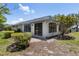 Backyard of the home featuring a small covered porch and mature landscaping at 1684 Pintail Way, Sarasota, FL 34231