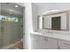 Modern bathroom with white vanity, large mirror, and a glass-enclosed walk-in shower at 1684 Pintail Way, Sarasota, FL 34231