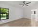 Neutral bedroom showcasing a ceiling fan, a window with lush views, and an ensuite bathroom at 1684 Pintail Way, Sarasota, FL 34231
