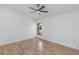 Minimalist bedroom featuring modern ceiling fan, wood-look floors, and a window with green views at 1684 Pintail Way, Sarasota, FL 34231
