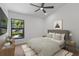 Well-lit bedroom with neutral walls, ceiling fan, and a large window with view of exterior landscape at 1684 Pintail Way, Sarasota, FL 34231