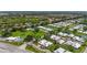 Wide aerial view showcasing a residential neighborhood with winding roads, lush greenery, and a community pool at 20 Idle Sands Dr, Venice, FL 34293